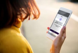 Women with mobile phone showing payments completed.