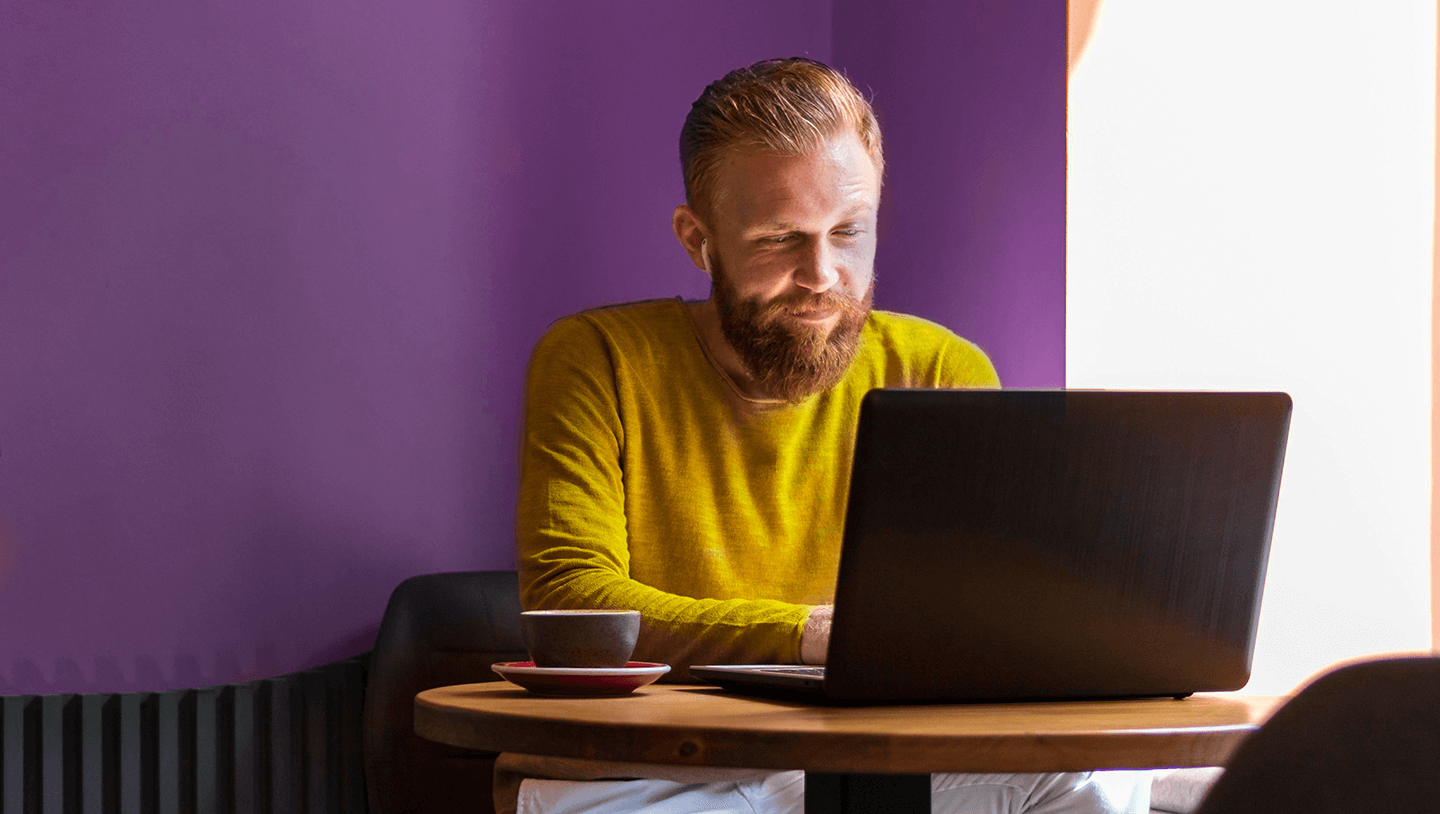 Merchants need to cut fees image of man with laptop making an Account to Account payment.